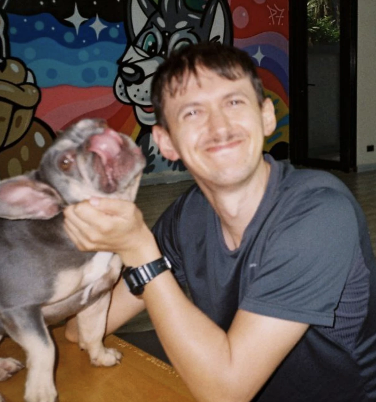 Mikhail Eshchenko smiling with a dog.